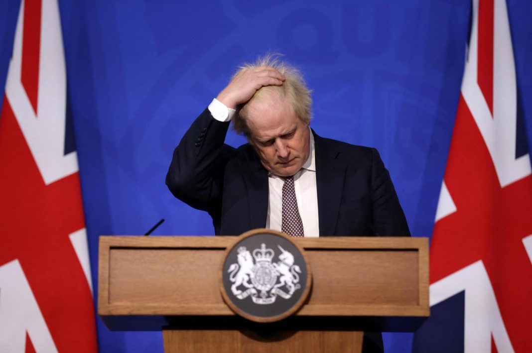 Perdana Menteri Inggris saat itu Boris Johnson memberi isyarat saat dia menghadiri pengarahan media tentang pembaruan COVID-19 terbaru di ruang pengarahan Downing Street di pusat kota London, 27 November 2021. (Foto: AFP)