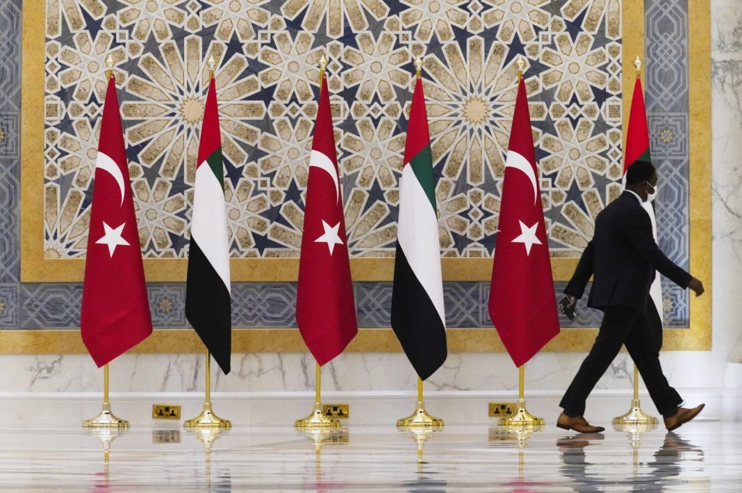 Seorang pejabat berjalan melewati bendera Turki dan Emirat di Qasr Al-Watan di Abu Dhabi, Uni Emirat Arab, Senin, 14 Februari 2022. (Foto File AP)