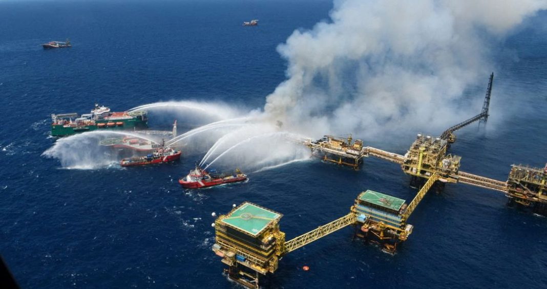 Kapal menyemprotkan air ke anjungan minyak lepas pantai yang terbakar di Lapangan Cantarell Pemex, di Teluk Campeche, Teluk Meksiko, Meksiko 7 Juli 2023.