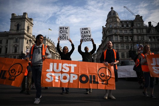 Aktivis iklim Just Stop Oil berbaris perlahan di Parliament Square di London, Inggris, 21 Juli 2023. (Foto: AFP}