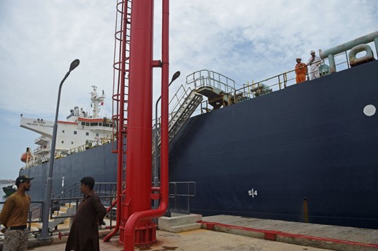 Seorang personel keamanan berdiri di samping kapal kargo Rusia yang membawa minyak mentah di pelabuhan Karachi di Karachi, Pakistan, 28 Juni 2023. (AFP Photo)