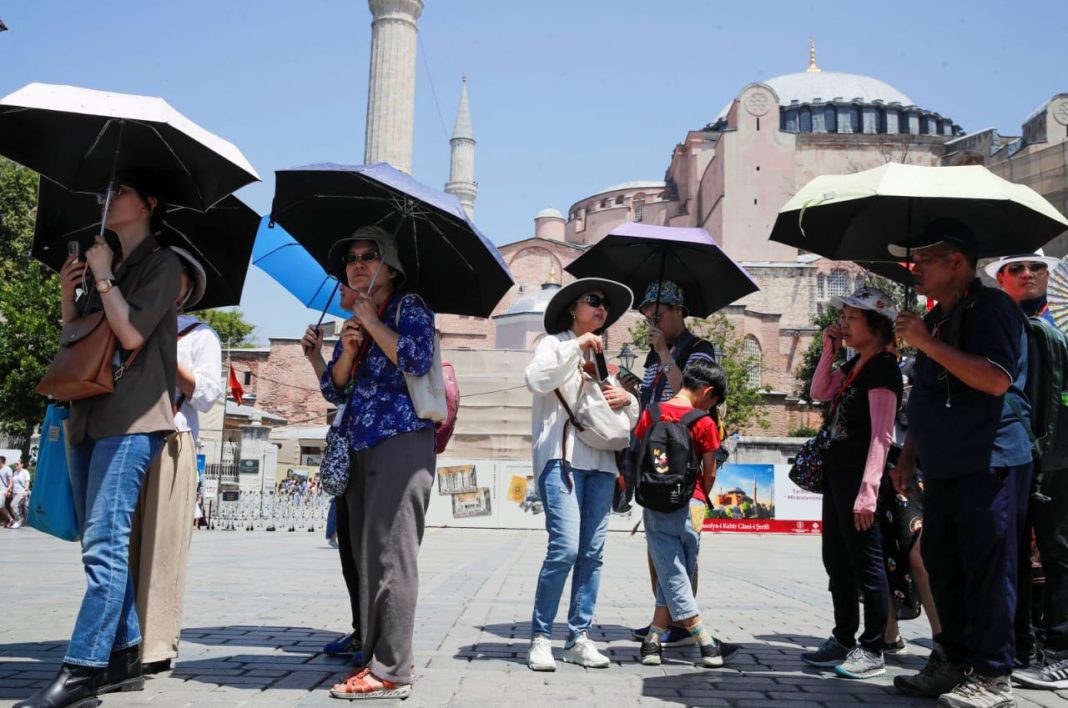 Wisatawan membawa payung untuk melindungi diri dari sinar matahari saat mengunjungi kota tua Istanbul, Turki, 20 Juli 2023. (Foto: Reuters)