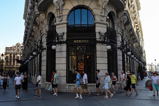 Wisatawan berjalan melewati sebuah toko mewah di Canalejas Square di Madrid, Spanyol, 10 Agustus 2023. (AFP Photo)