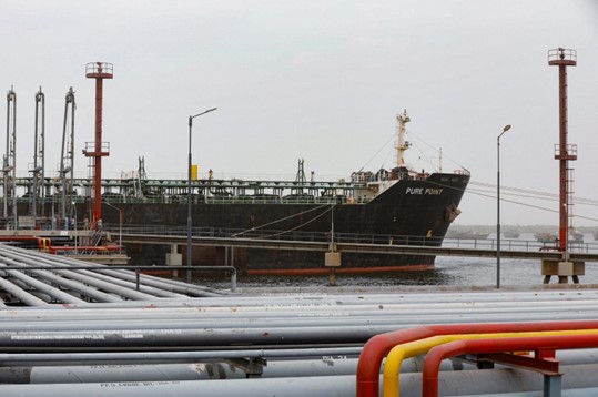 Anggota kru memeriksa dek kargo minyak Rusia Pure Point, membawa minyak mentah, berlabuh di sebuah pelabuhan di Karachi, Pakistan, 13 Juni 2023. (Foto: Reuters)