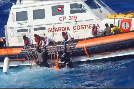 Tim penyelamat penjaga pantai Italia membantu para migran untuk naik perahu penyelamat selama operasi yang berlangsung di selatan Lampedusa, Italia, 5 Agustus 2023.