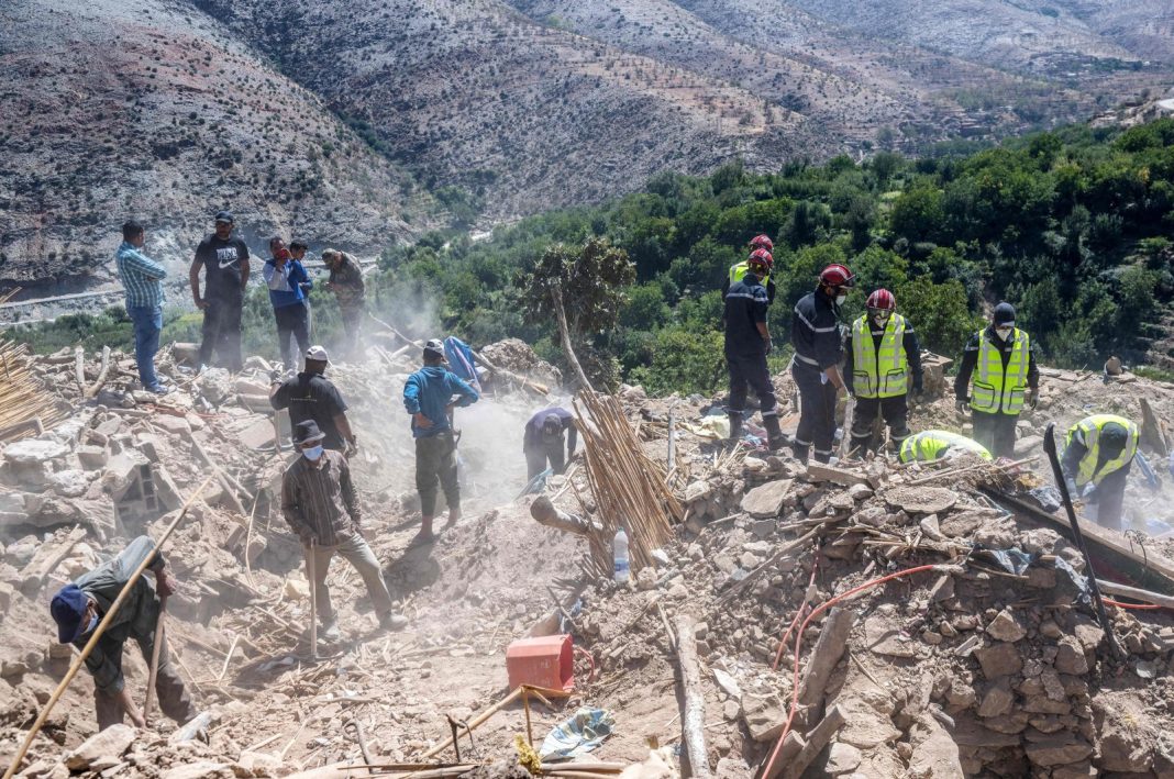 im penyelamat dan penduduk desa menyaring puing-puing bangunan yang hancur di sebuah desa dekat Amizmiz, Maroko tengah, 13 September 2023. (AFP Photo)