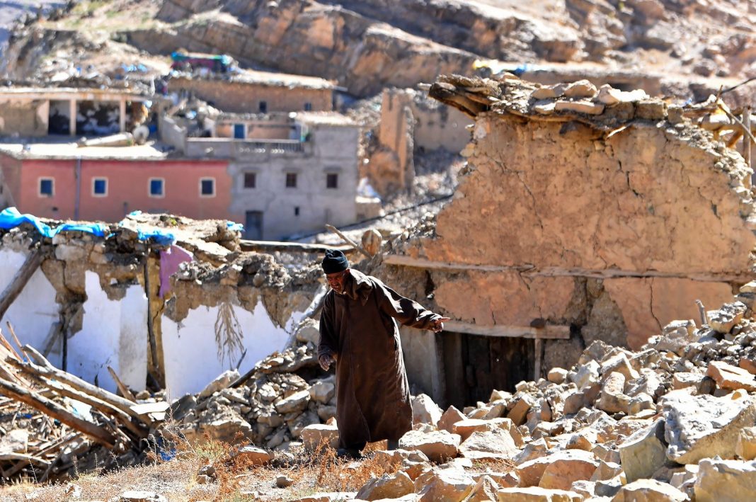 Seorang pria berjalan melewati puing-puing dari bangunan yang hancur di desa yang dilanda gempa, Ardouz, Maroko, 14 September 2023. (AFP Photo)